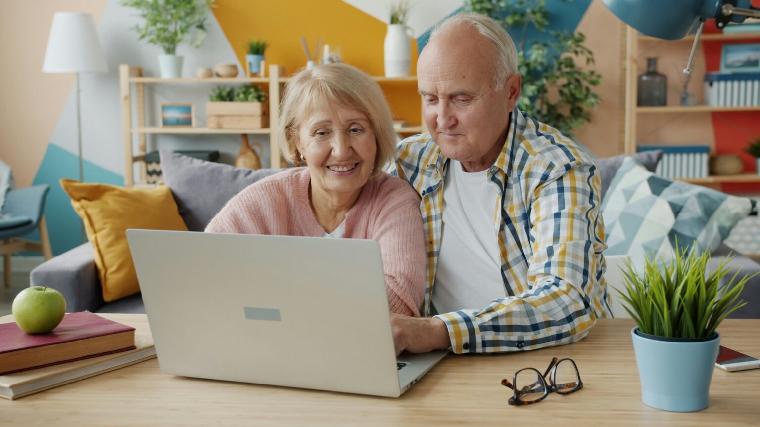 Senior couple looking at a laptop together at home